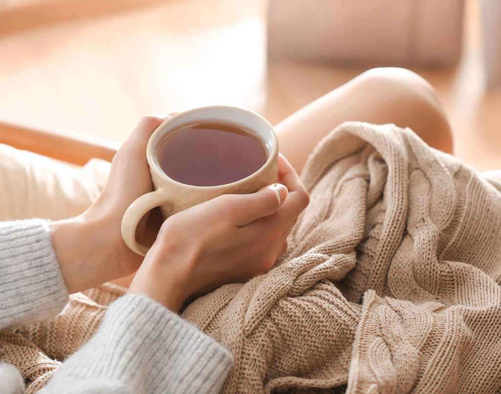 woman drinking tea in a warm, cozy environment