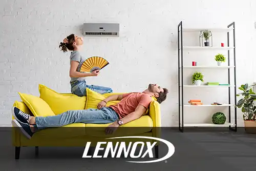 Bormida Heating & Cooling—A man and a woman sit on a yellow couch under their AC, trying to cool down from the summer heat in Springfield, IL.