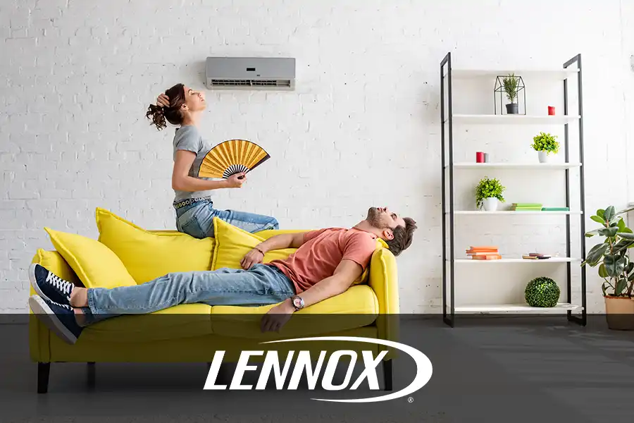 Bormida Heating & Cooling—A man and a woman sit on a yellow couch under their AC, trying to cool down from the summer heat in Springfield, IL.