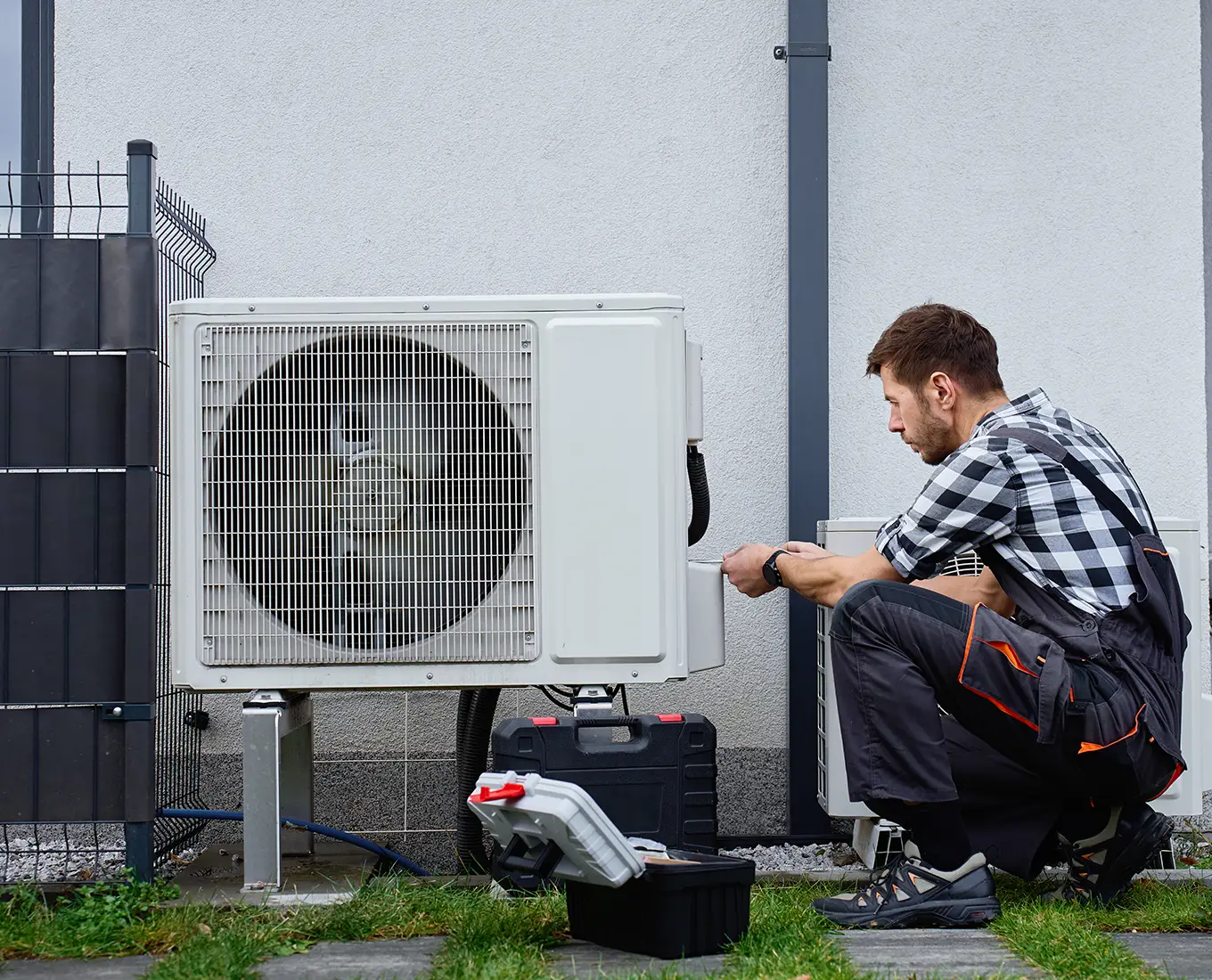 HVAC technician repairing an outdoor air conditioning unit during a 24/7 HVAC service call in Springfield, IL.