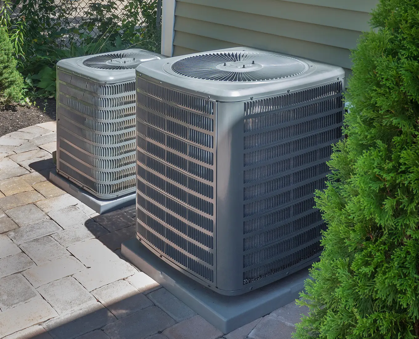 Two outdoor air conditioning condenser units installed beside a home as part of professional cooling services in Springfield, IL.