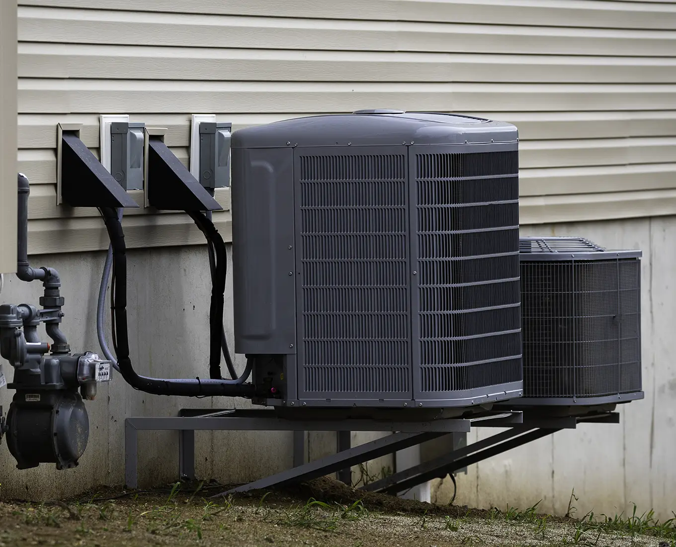 Two outdoor air conditioner condenser units installed beside a home as part of professional AC installation and replacement services in Springfield, IL.