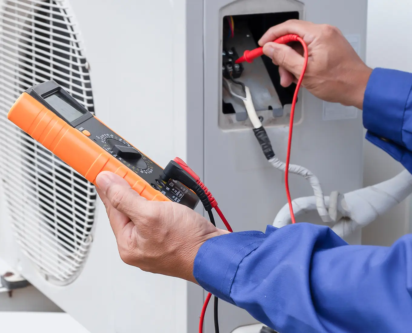 Technician performing routine maintenance on a residential air conditioning condenser unit in Springfield, IL.