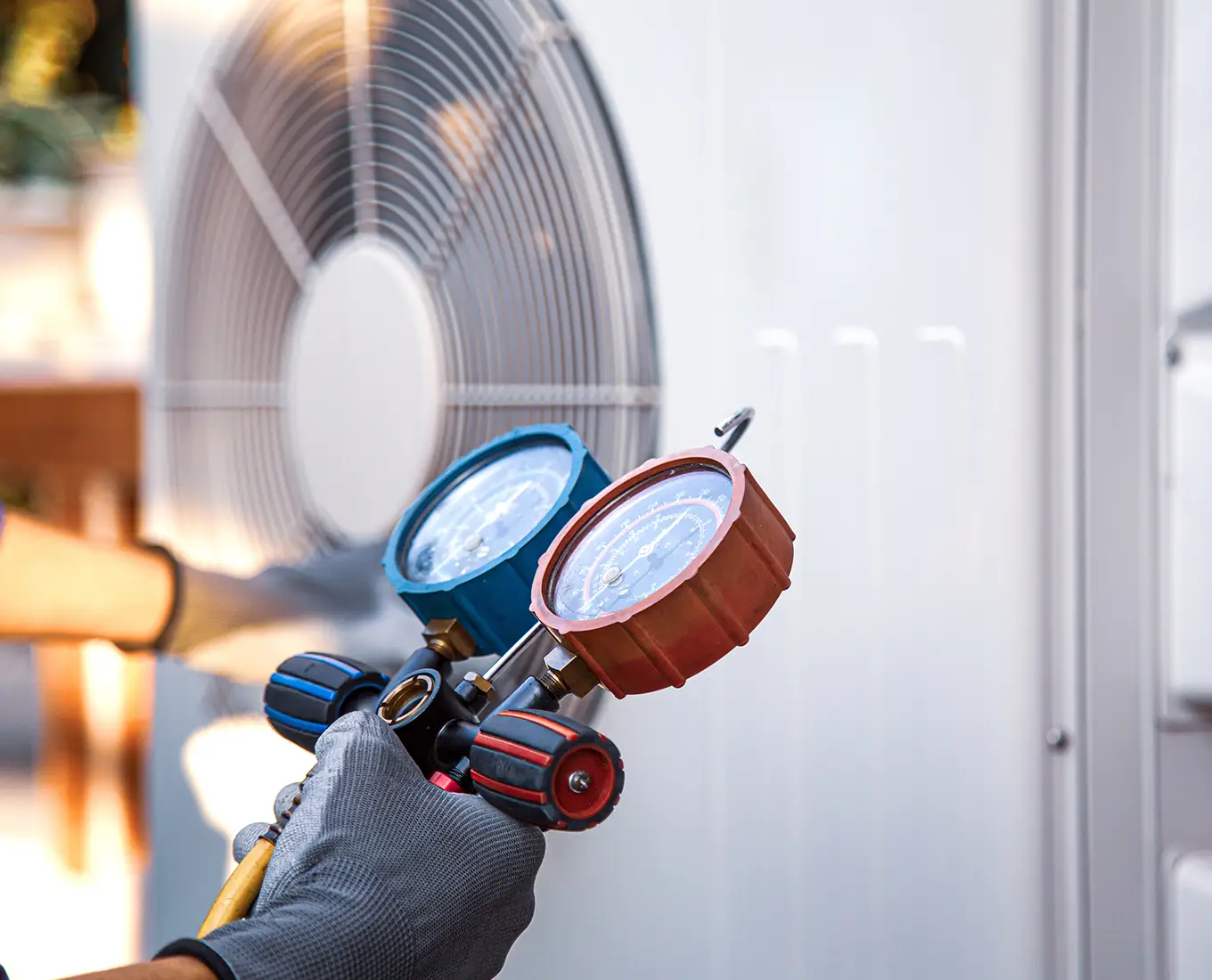 HVAC technician using gauges to diagnose refrigerant levels during air conditioning repair service in Springfield, IL.