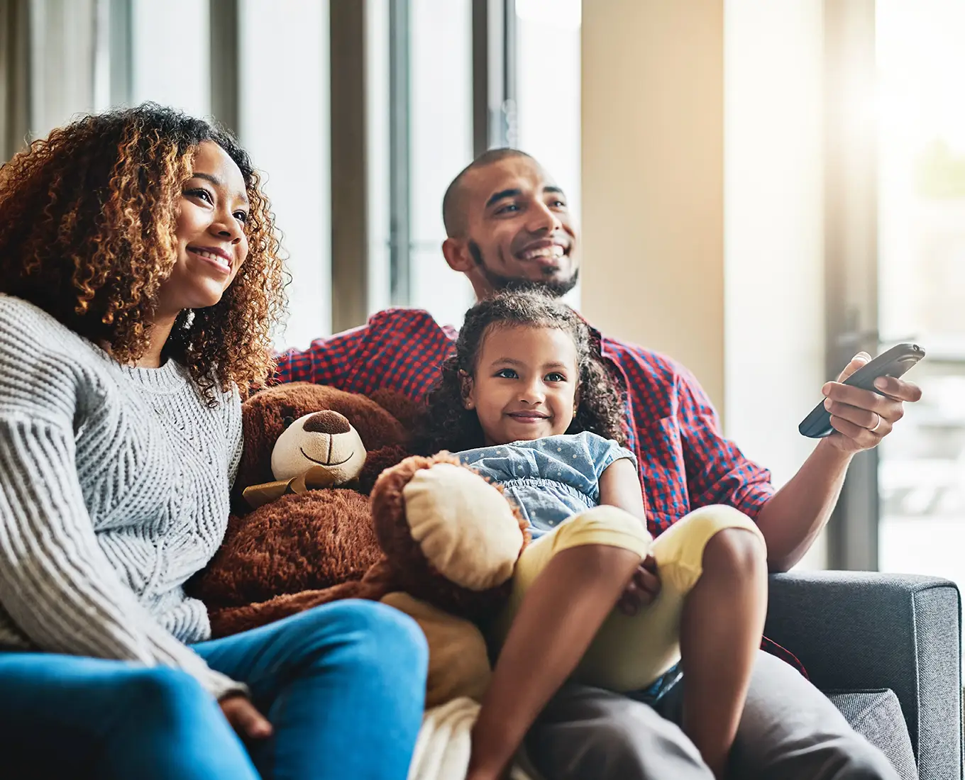 Family relaxing together on the couch in a comfortable home after emergency air conditioning repair service in Springfield, IL.