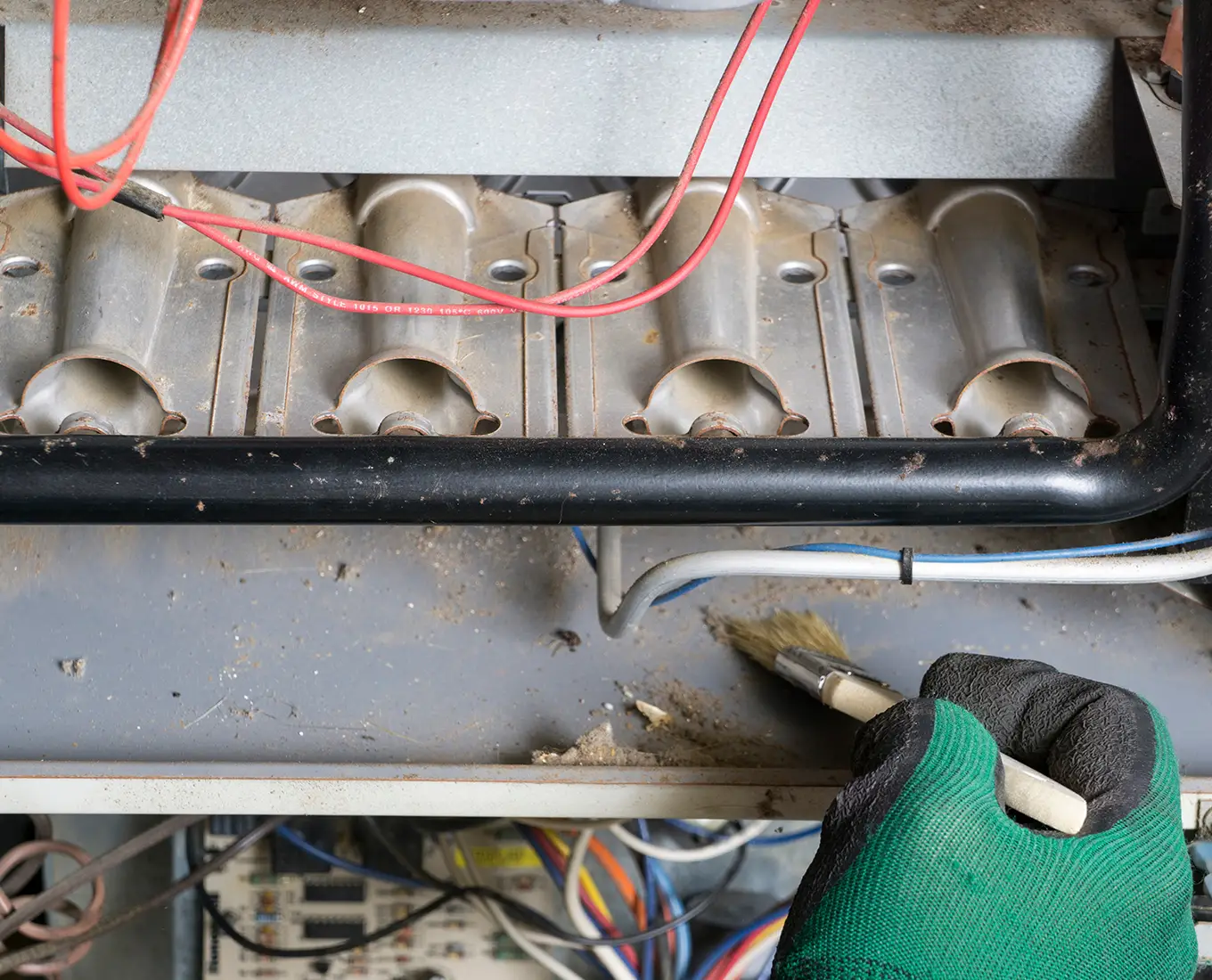 HVAC technician cleaning furnace burners during a detailed furnace maintenance inspection for improved heating efficiency in Springfield, IL.