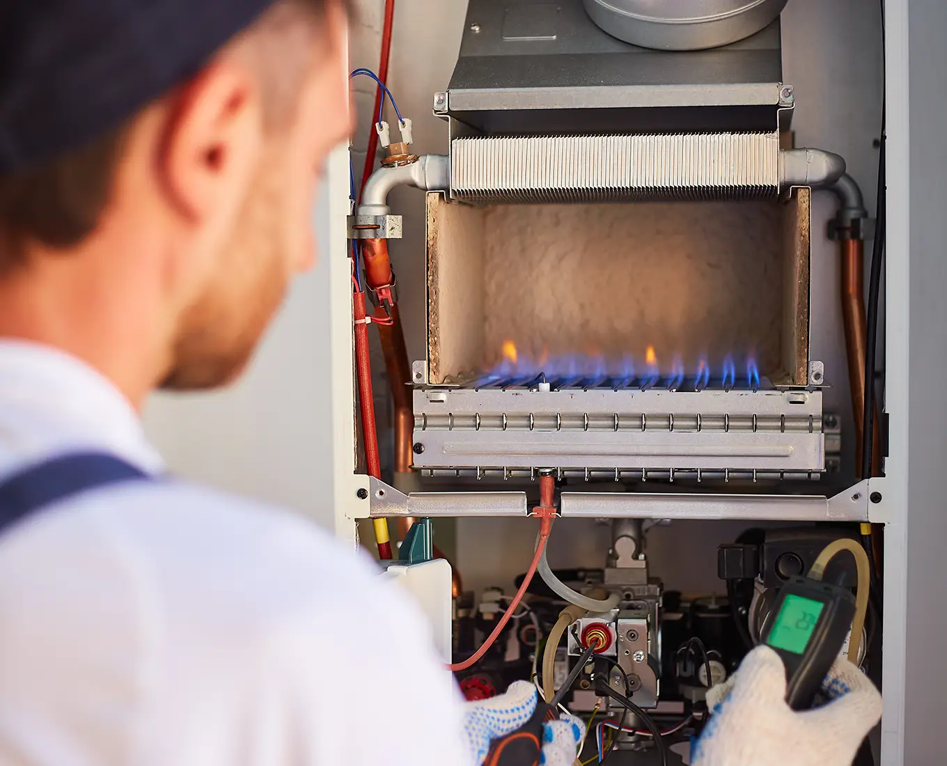 Technician inspecting a gas furnace burner during furnace repair service by Bormida Heating & Cooling in Springfield, IL.