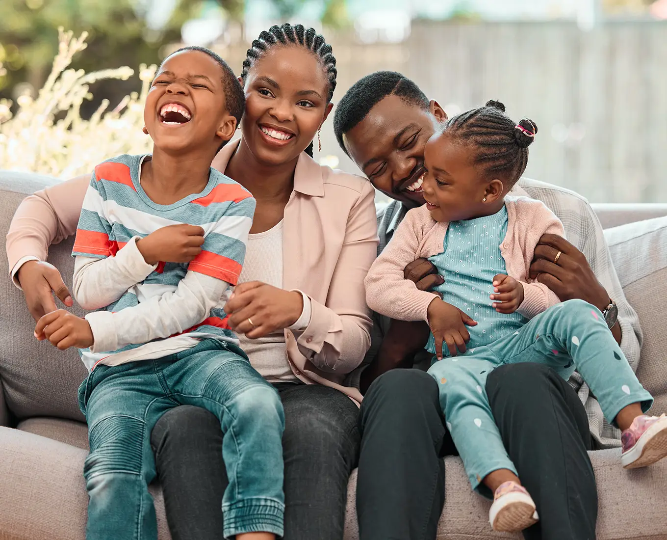 Smiling family sitting on a couch enjoying a comfortable home environment with complete heating and cooling solutions in Springfield, IL