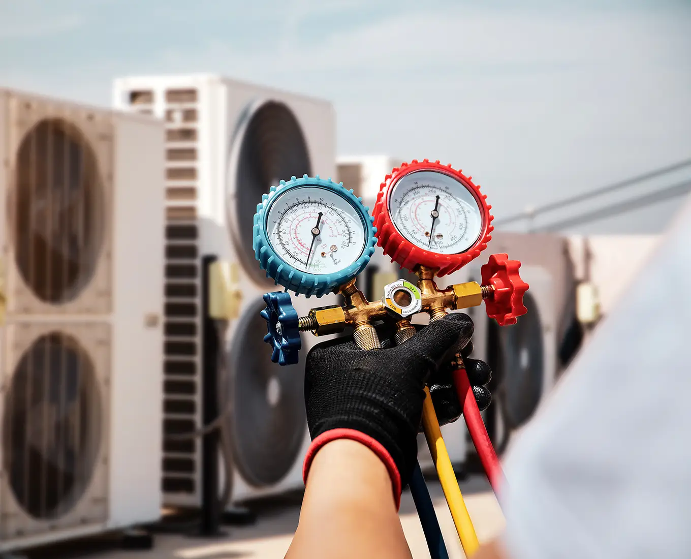 HVAC technician using pressure gauges to inspect a commercial air conditioning system during commercial HVAC service in Springfield, IL.
