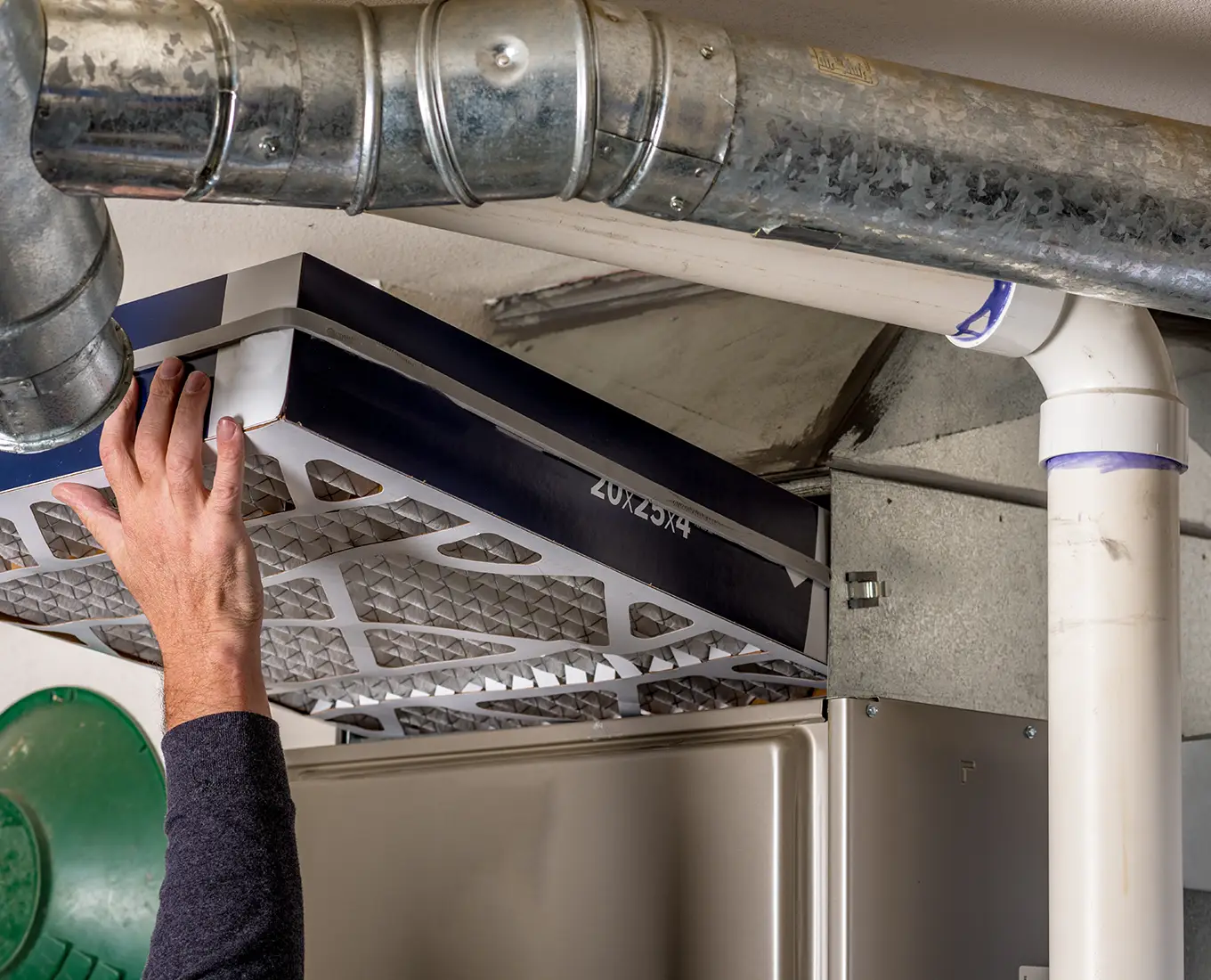 Technician replacing a large air filter inside a commercial HVAC system during routine commercial furnace maintenance in Springfield, IL.