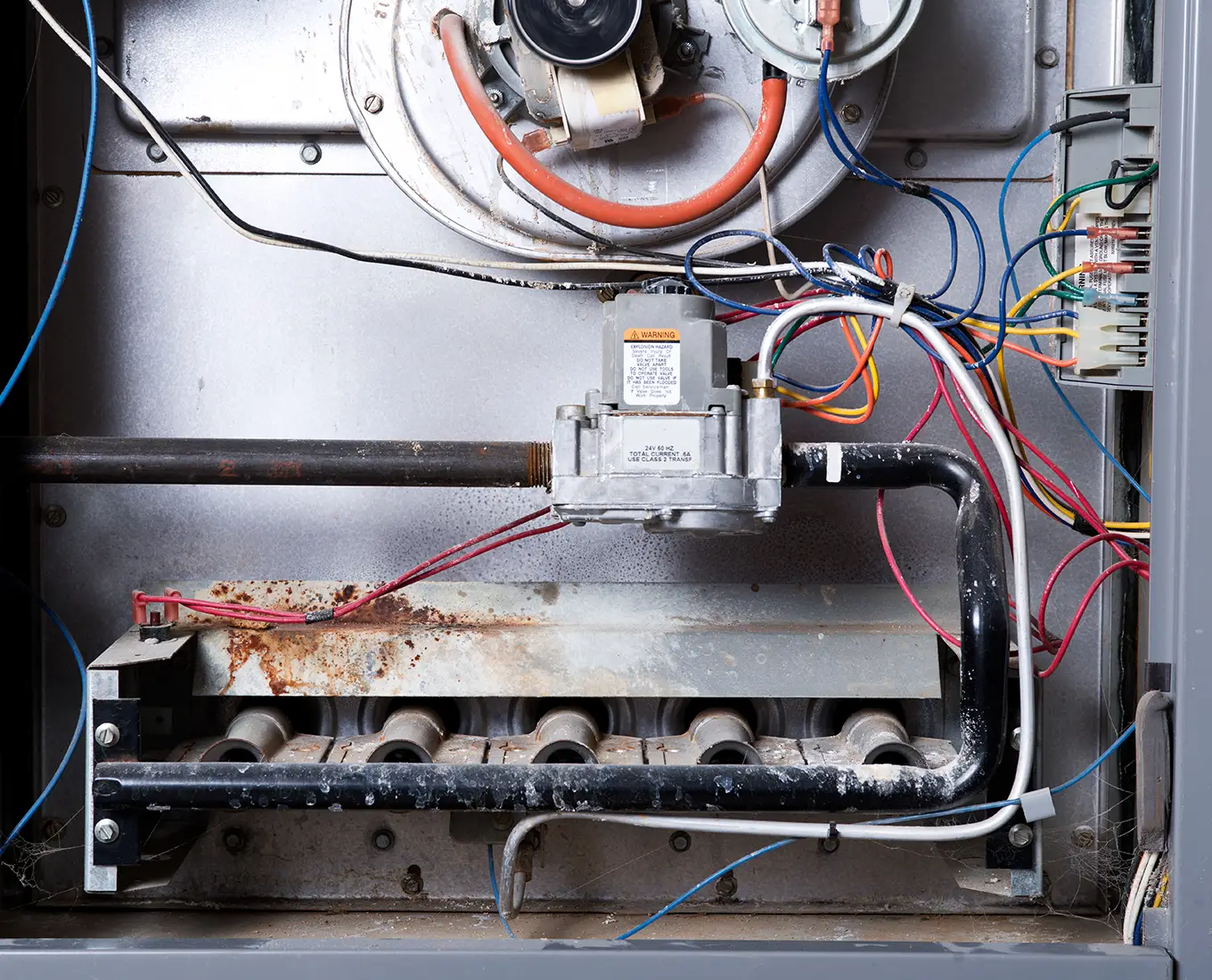 Furnace interior with worn components and wiring showing common heating repair issues in Springfield, IL