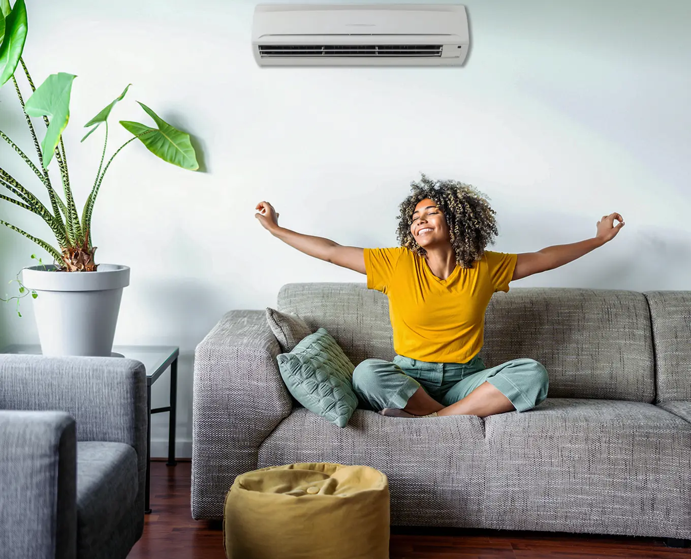 Homeowner relaxing comfortably under a wall-mounted mini-split system after ductless HVAC installation in Springfield, IL.