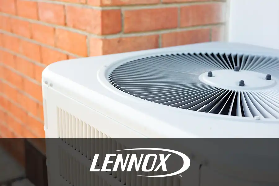 Bormida Heating & Cooling—An outdoor air conditioning unit sits beside a red brick wall, highlighting the system’s large circular fan and ventilation grilles.